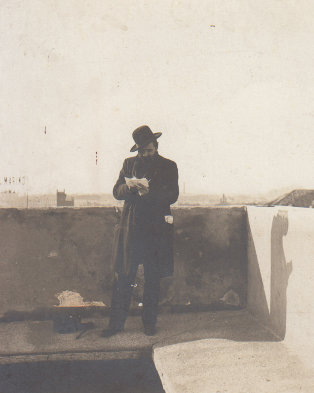 Foto storica di Giuseppe Mentessi che disegna su un balcone